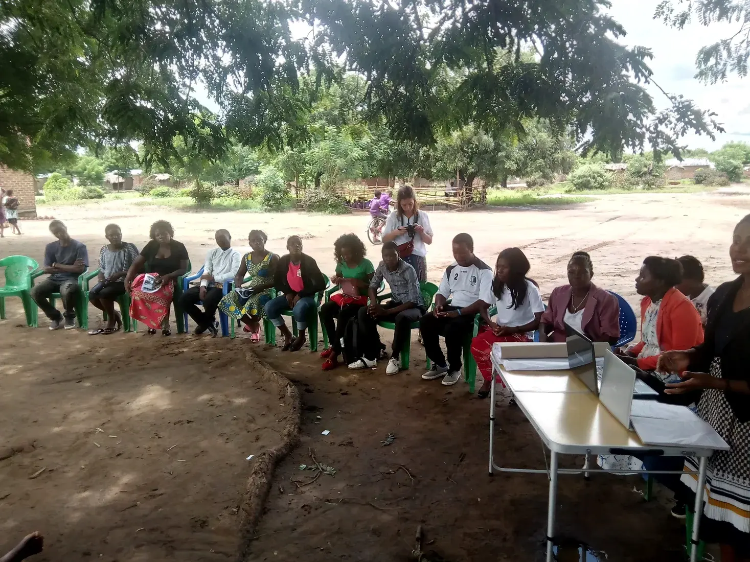 Community members seated in a circle during a facilitated outdoor health discussion