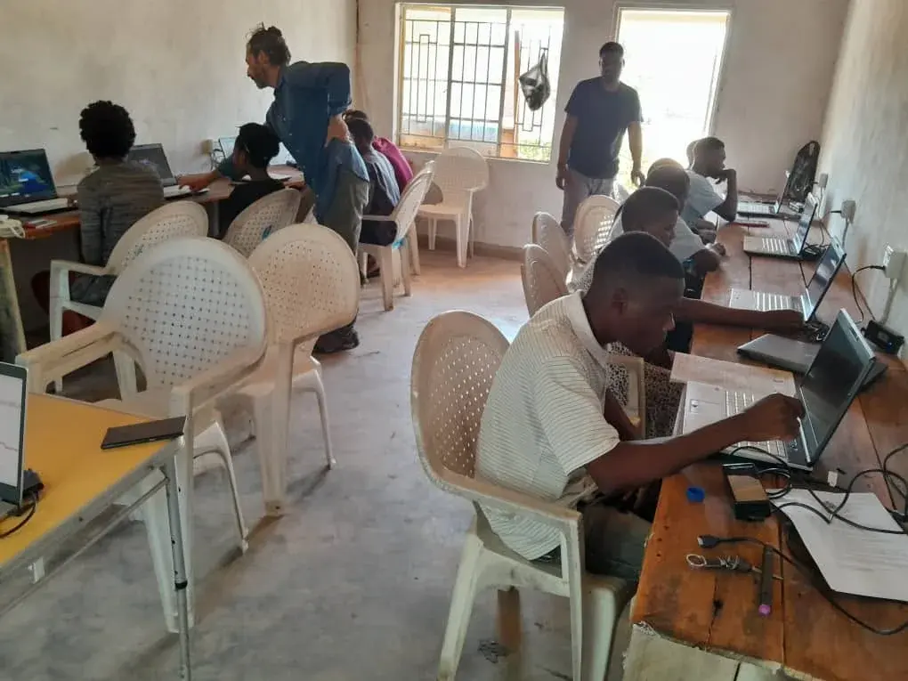 Young adults participating in a supervised computer-training session using laptops