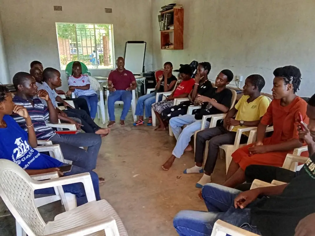 Adult SURCOD participants and facilitators taking part in a structured group discussion indoors