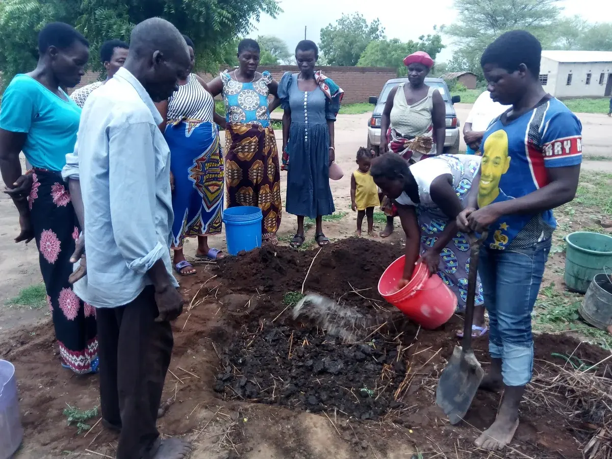 Community members examining organic material during a practical soil-health demonstration