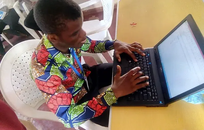A SURCOD computer-training participant demonstrating Microsoft Excel on a laptop